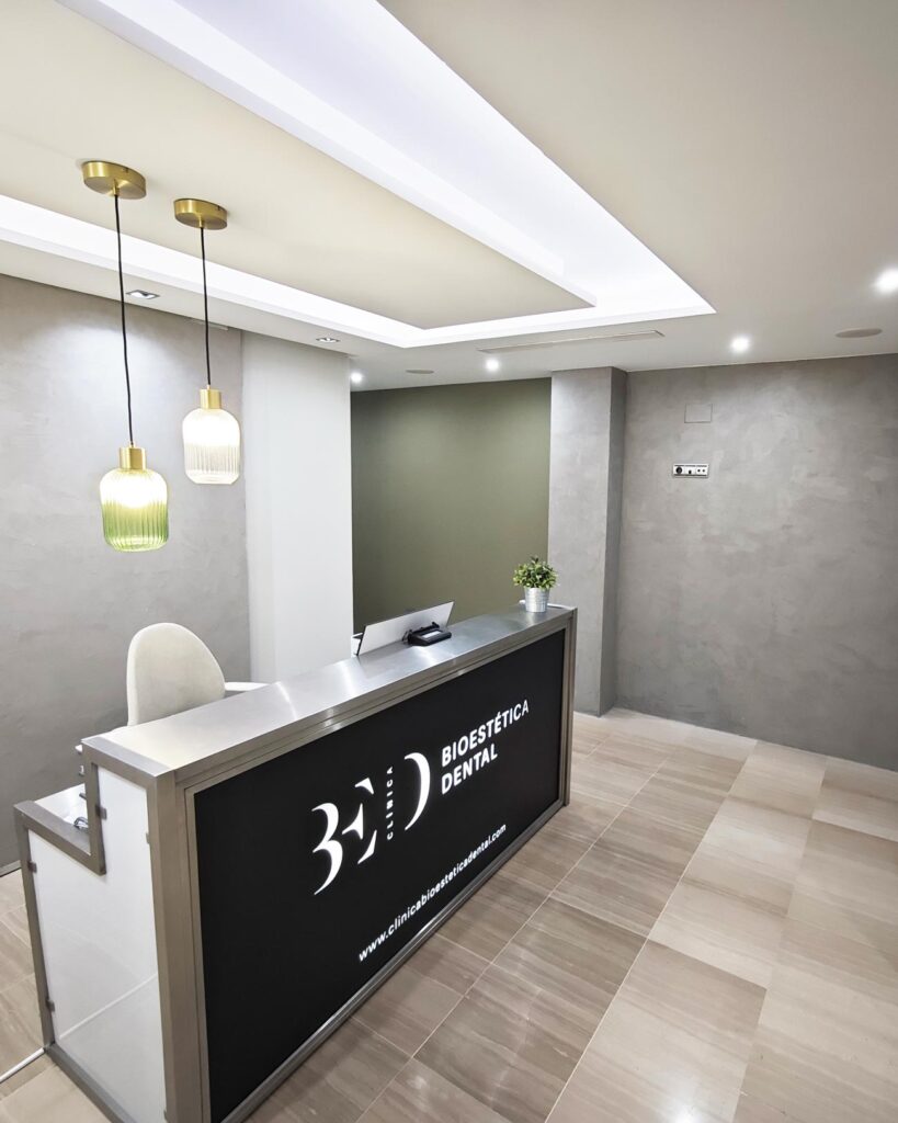 Vista de la recepción de la clínica, ambiente elegante, moderno y luminoso.