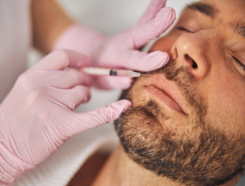 Hombre joven recibiendo un tratamiento de aumento de labios.