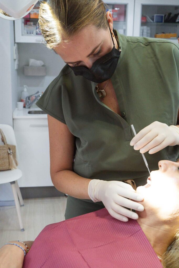 Dentista inspeccionando la boca de un paciente